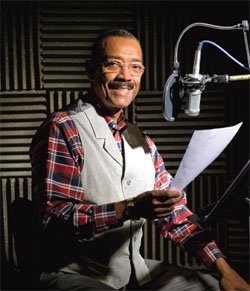 A man holding papers in front of a microphone.