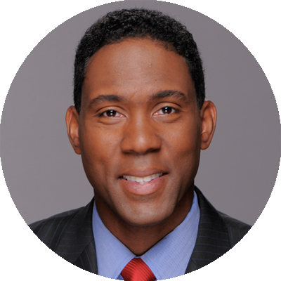 A man in a suit and tie smiling for the camera.